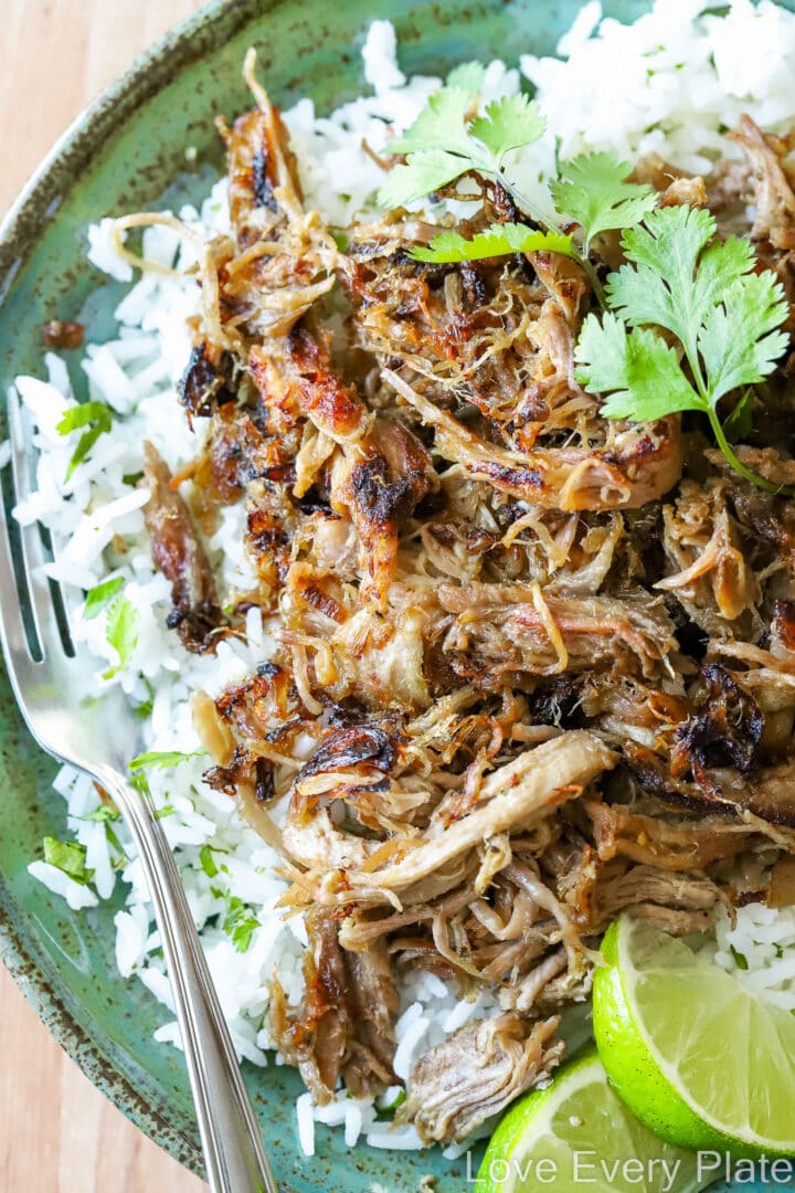 green plate of pulled pork with rice and lime slices