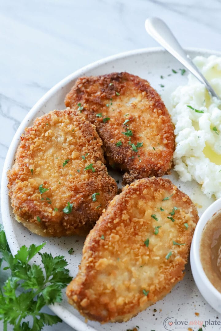 three pork chops with mashed potatoes