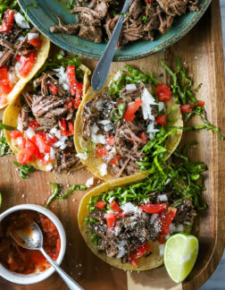 tacos filled with shredded beef, onion, tomato and lettuce.
