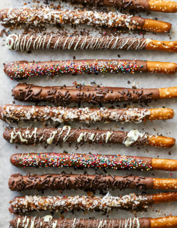 tray of assorted chocolate covered pretzel rods with different toppings.