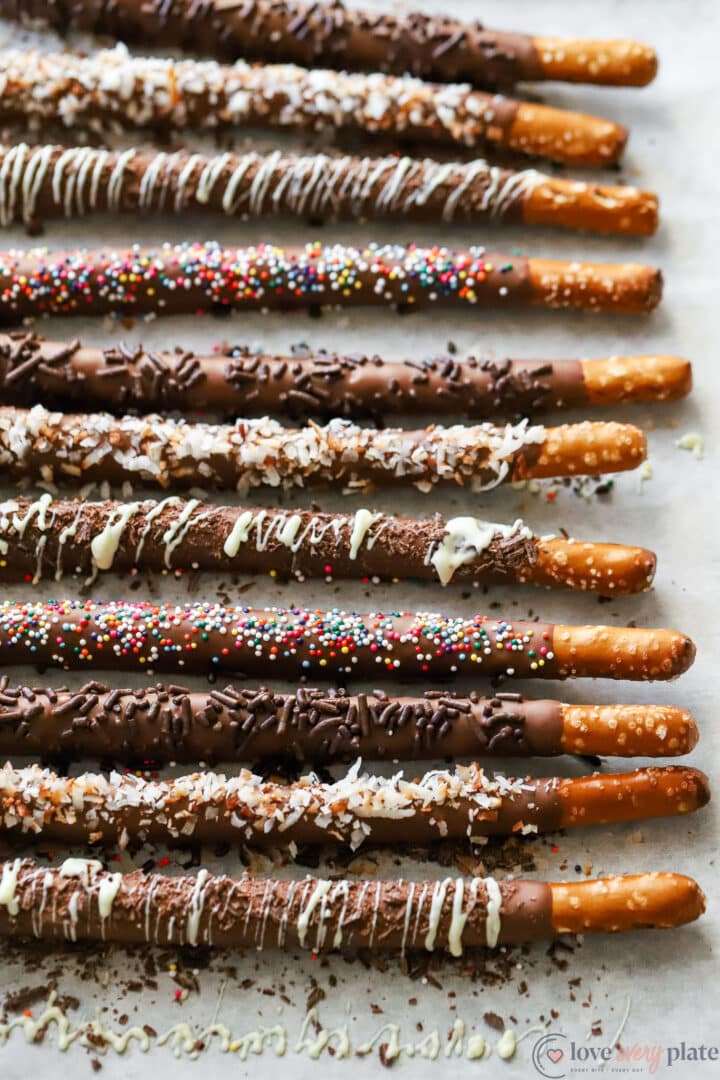 tray of assorted chocolate covered pretzel rods with different toppings.
