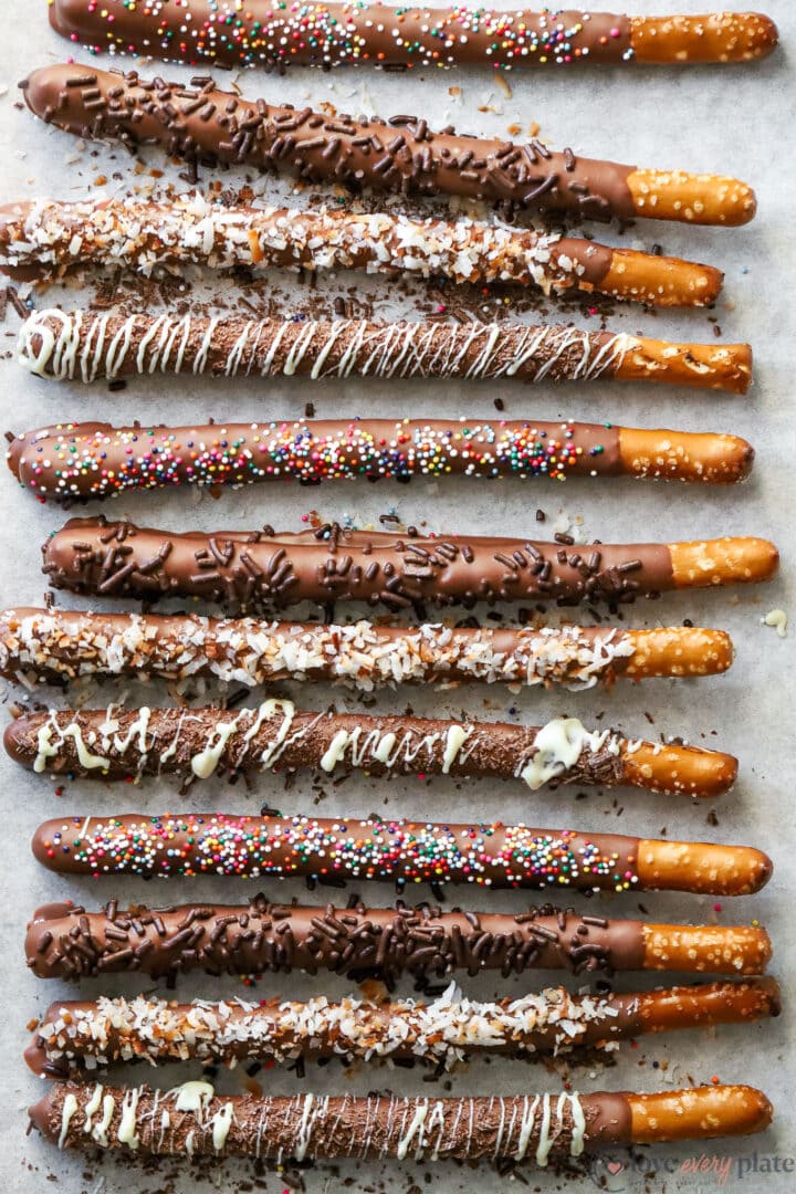 tray of assorted chocolate covered pretzel rods with different toppings.