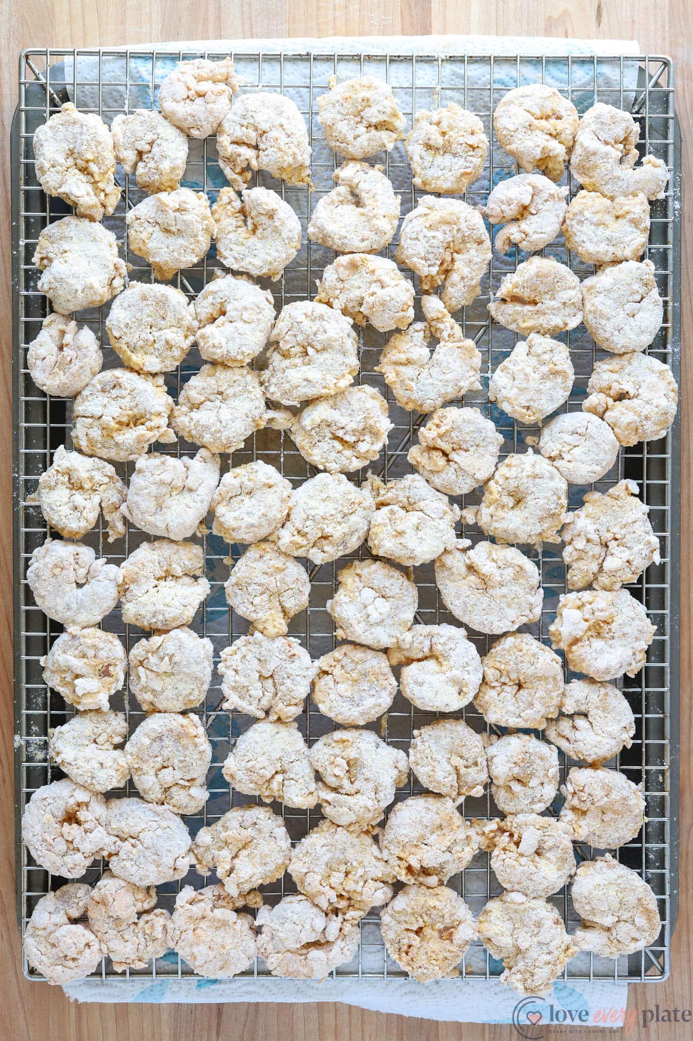 cooling rack full of breaded shrimp to be fried