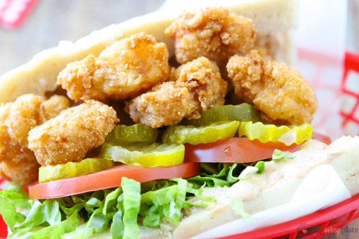 side view of a shrimp sandwich with pickles, lettuce and tomato