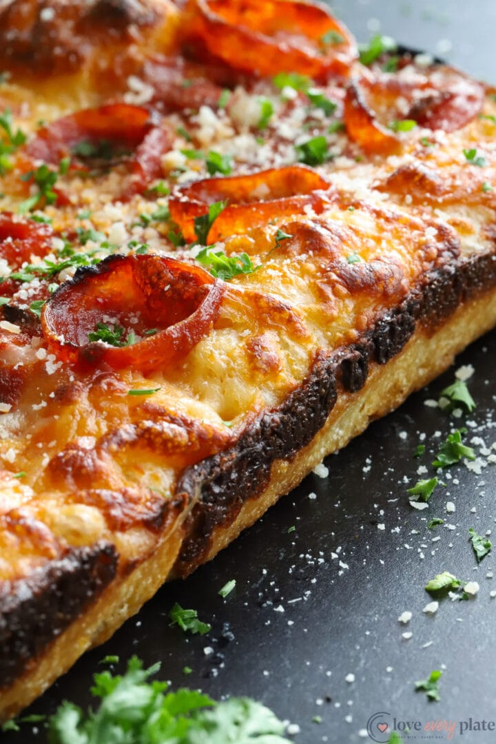 blackened crust on the side of a whole, square pizza