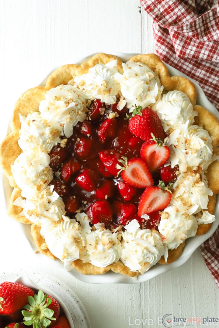 top view of a strawberry pie with whipped cream and coconut