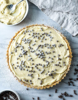 top view of a cannoli tart, garnished with chocolate chips and powdered sugar.