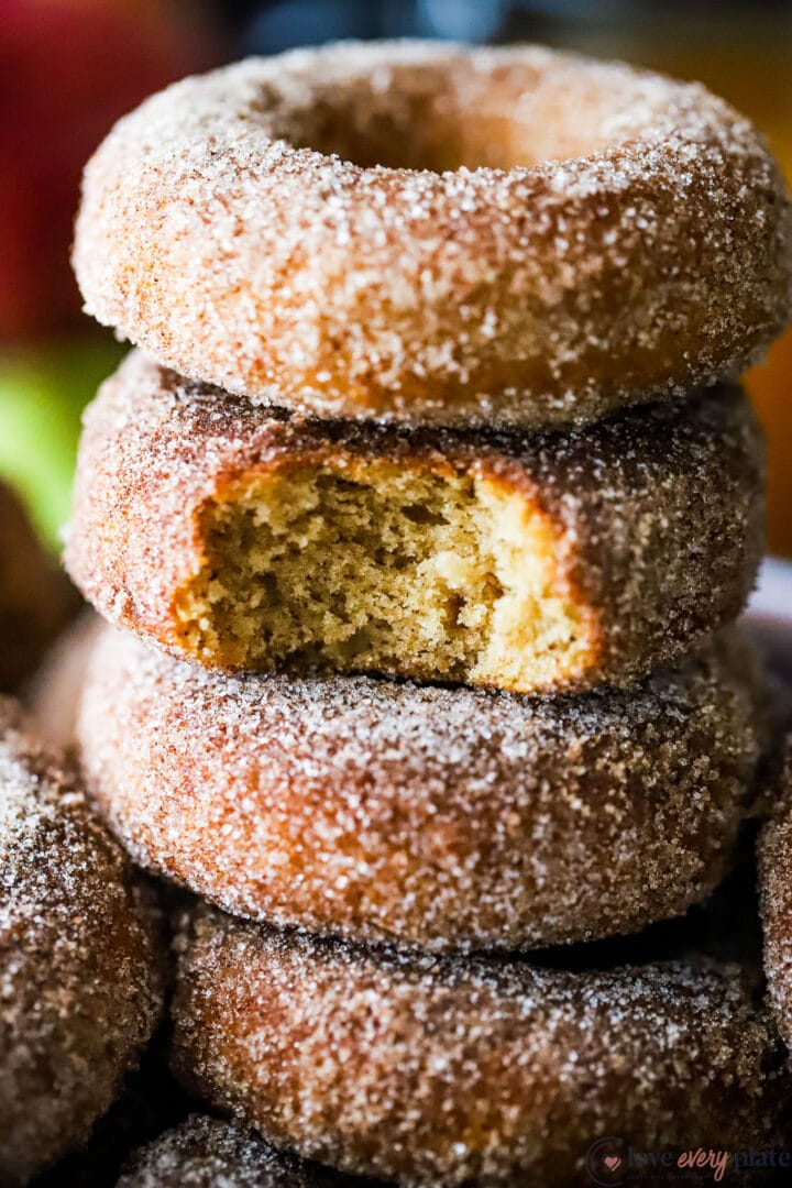 stack of cinnamon sugar dusted donuts with a bite taken out