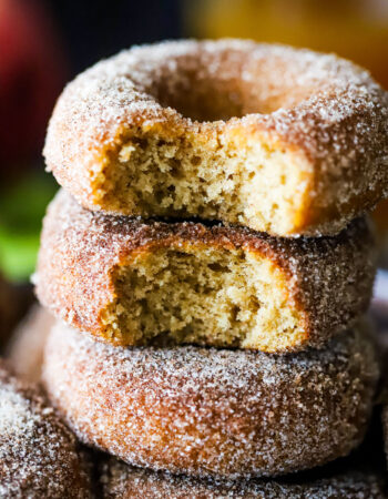 stack of cinnamon sugar dusted donuts with a bite taken out