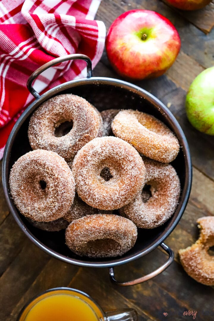 top view of copper bowl of cinnamon sugar dusted donuts