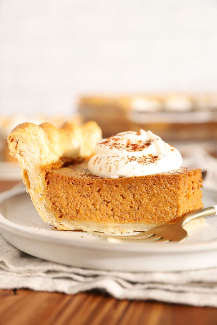 slice of pumpkin pie with a dollop of whipped cream on top