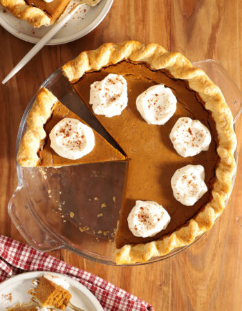 top view of a pumpkin pie with 2 slices removed and set to the side