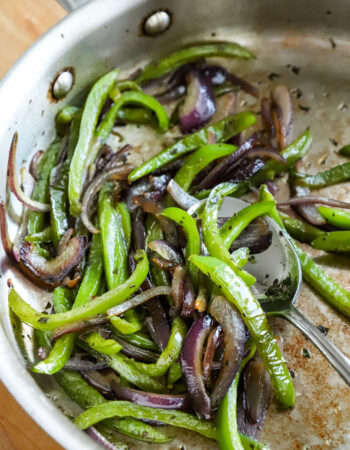 skillet of sliced green peppers and red onions