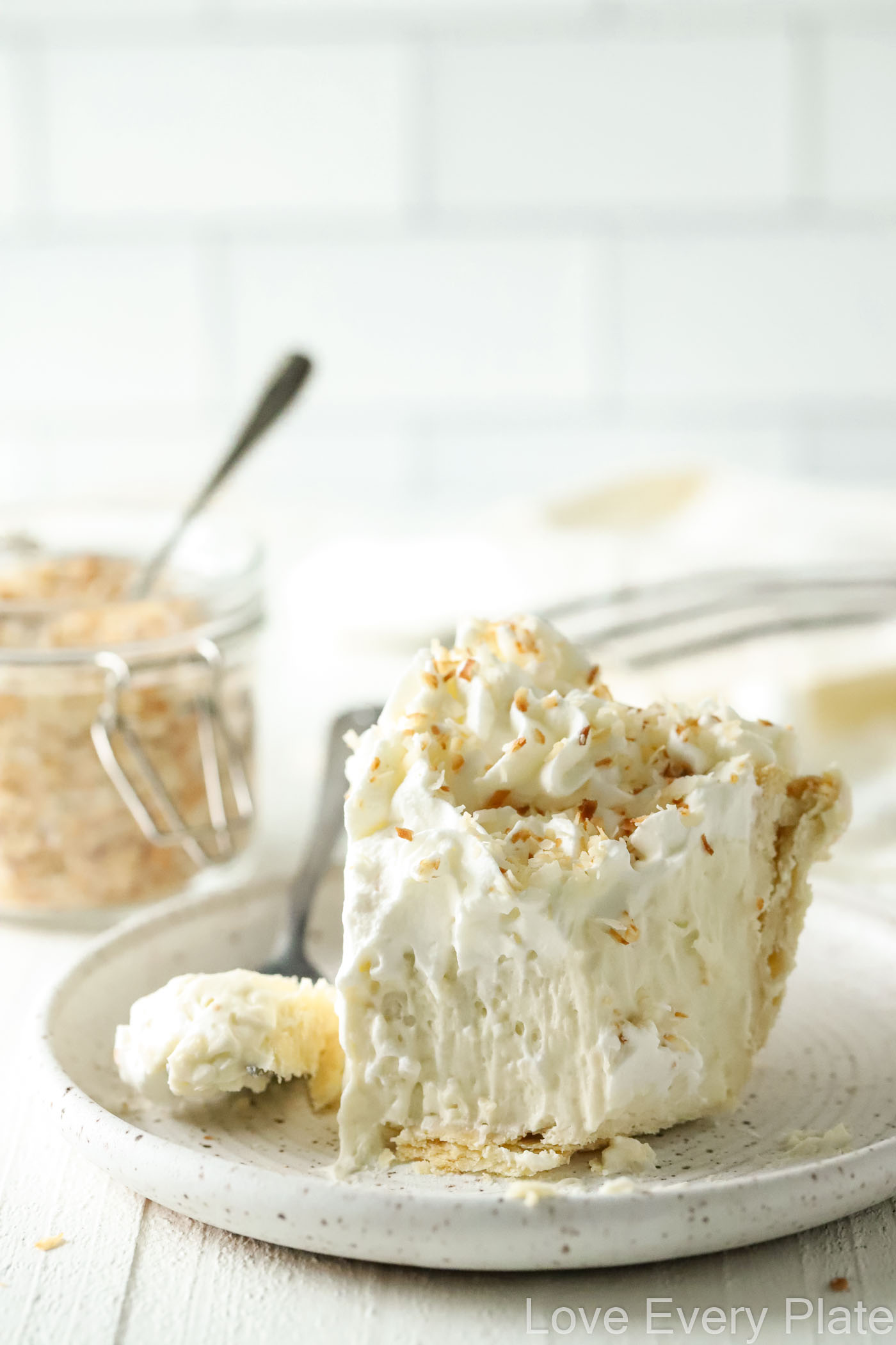 slice of coconut cream pie with a bite taken from it