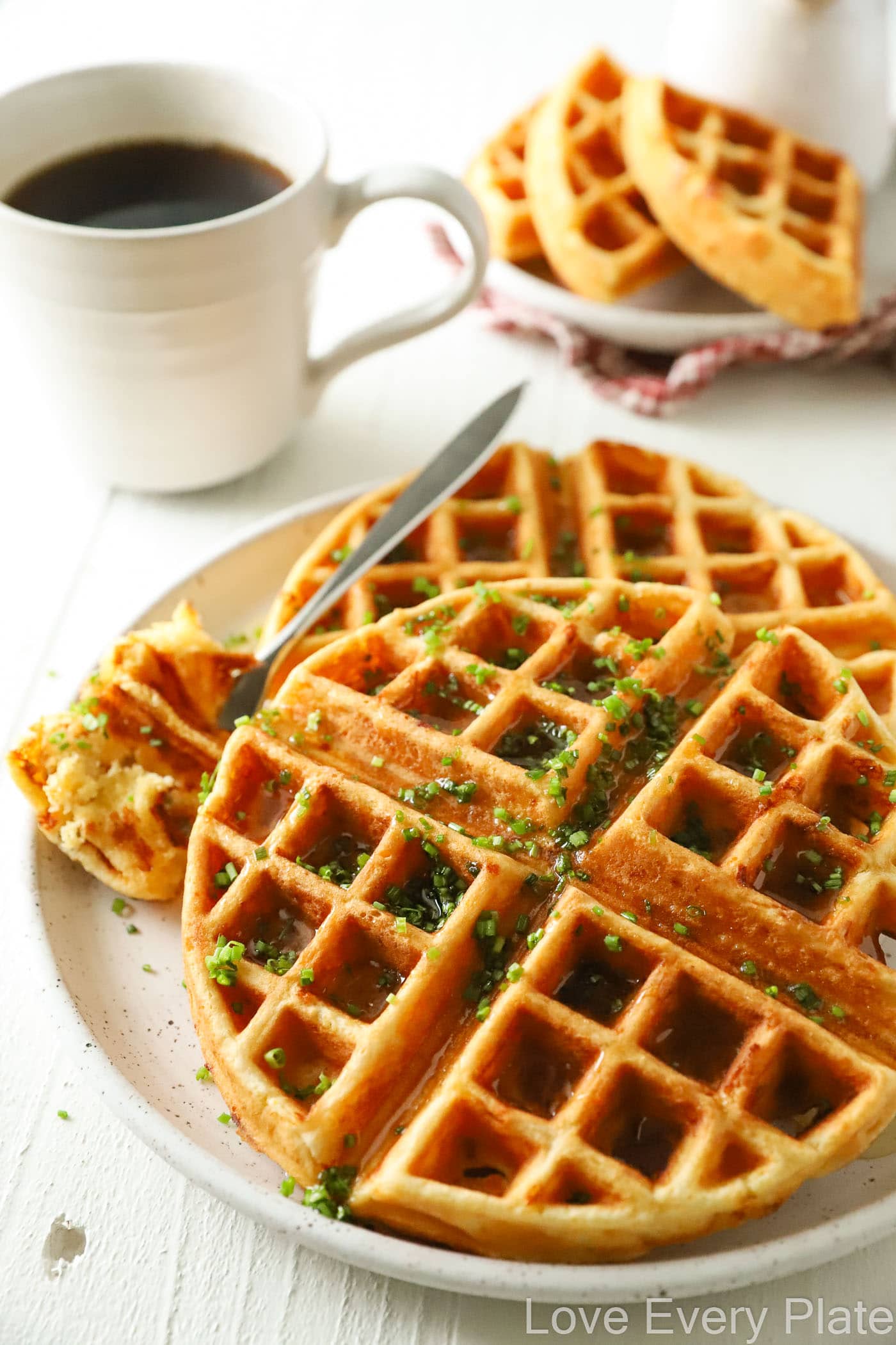 waffles with chives sprinkled on top and a cup of coffee