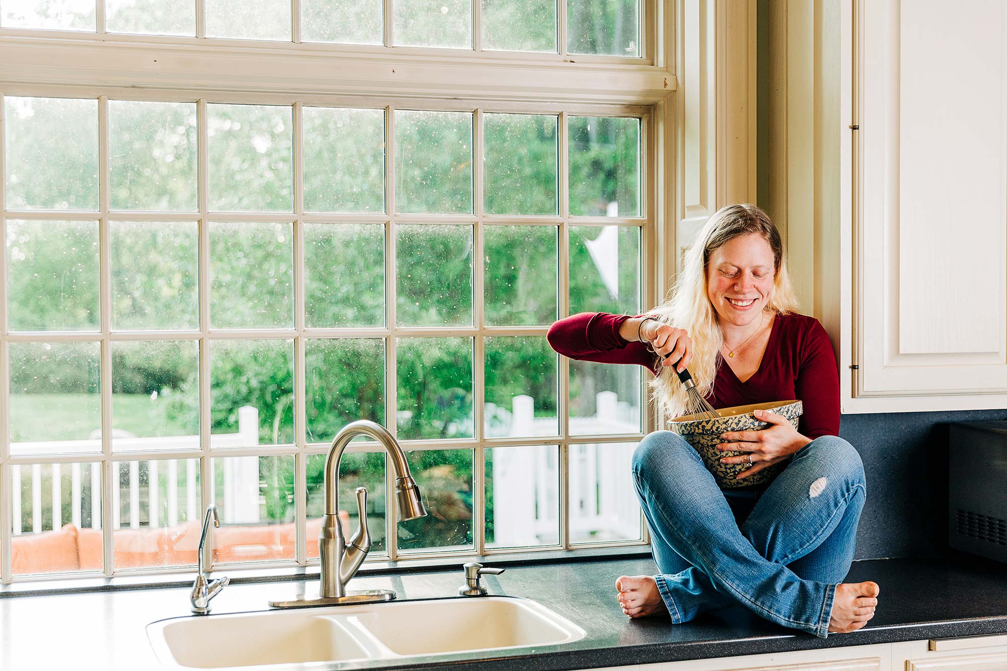 Megan sitting on the kitchen counter with a mixing bowl