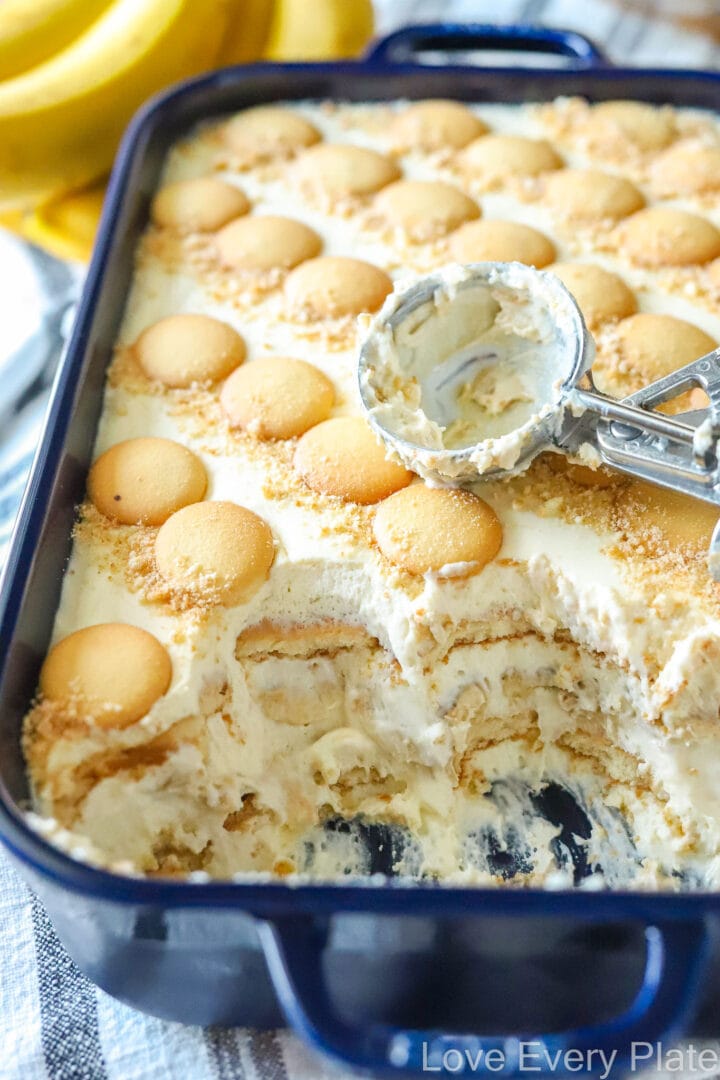 pan of layered banana pudding with scoops removed and scoop on top