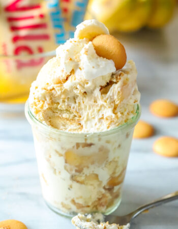 cup of banana pudding with whipped cream and vanilla cookies