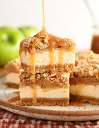 small stack of caramel apple cheesecake bars being drizzled with caramel sauce