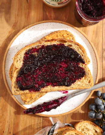 overhead shot of 2 slices of wheat bread with peanut butter and jelly on top