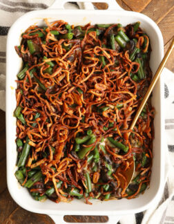 a white rectangular baking dish with green bean casserole, topped with french fried onions