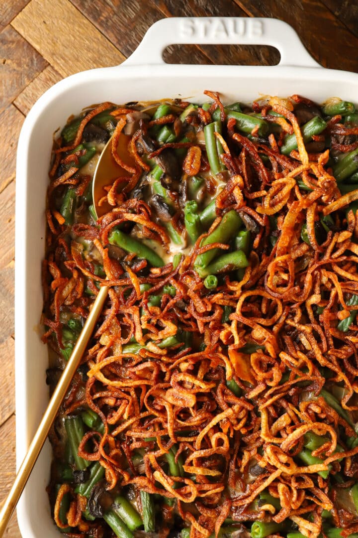 a white rectangular baking dish with green bean casserole, topped with french fried onions