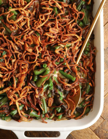 a white rectangular baking dish with green bean casserole, topped with french fried onions