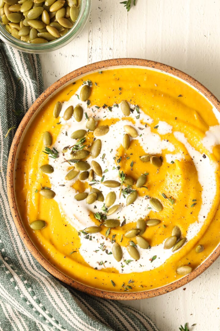 bowl of butternut squash soup and small dish of pepitas