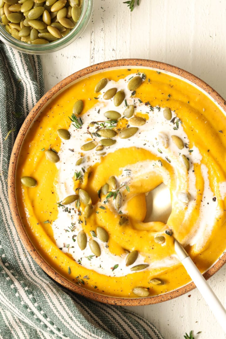 bowl of butternut squash soup and small dish of pepitas