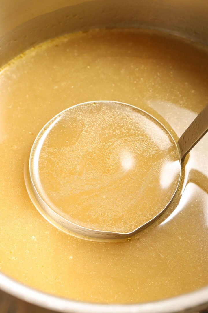 ladle of turkey stock in a pot