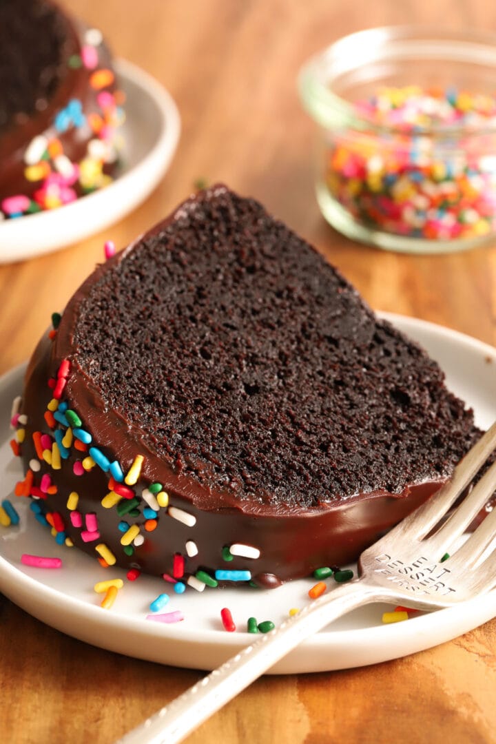 slice of chocolate cake on a white plate with a fork