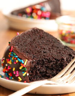 slice of chocolate cake on a white plate with a fork