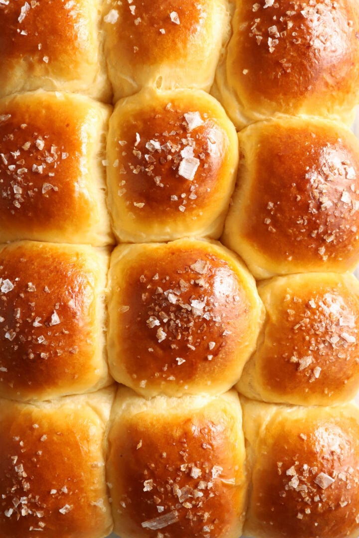 tray of dinner rolls with salt on top.