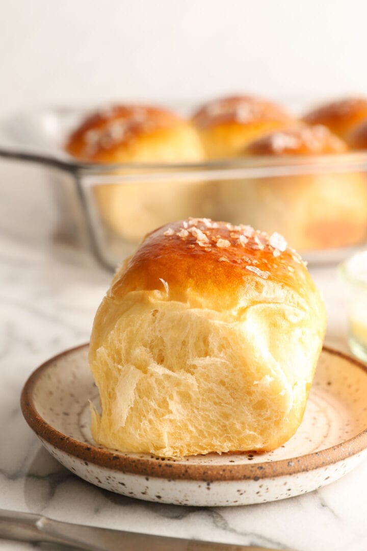 One dinner roll on a white plate.