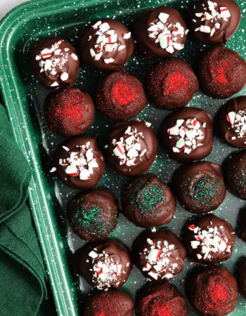 green speckled tray of oreo truffles that have been decorated with crushed candy canes.