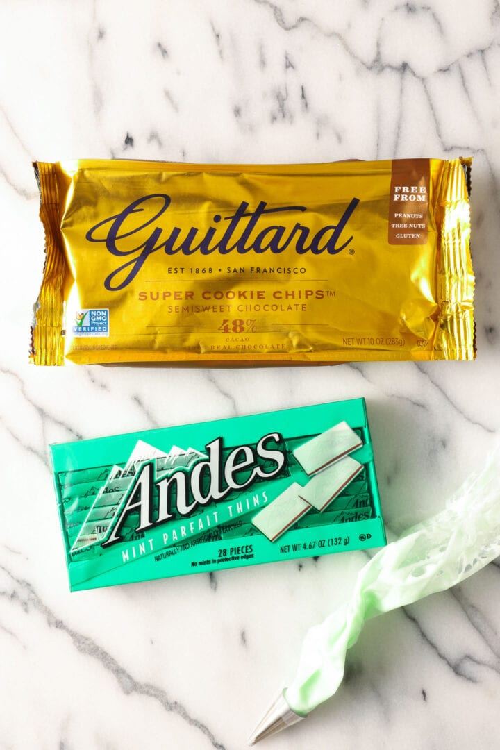 a bag of chocolate chips, a box of green Andes mint candies next to a piping bag of green icing