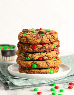 stack of 5 christmas chocolate chip cookies with red and green candies