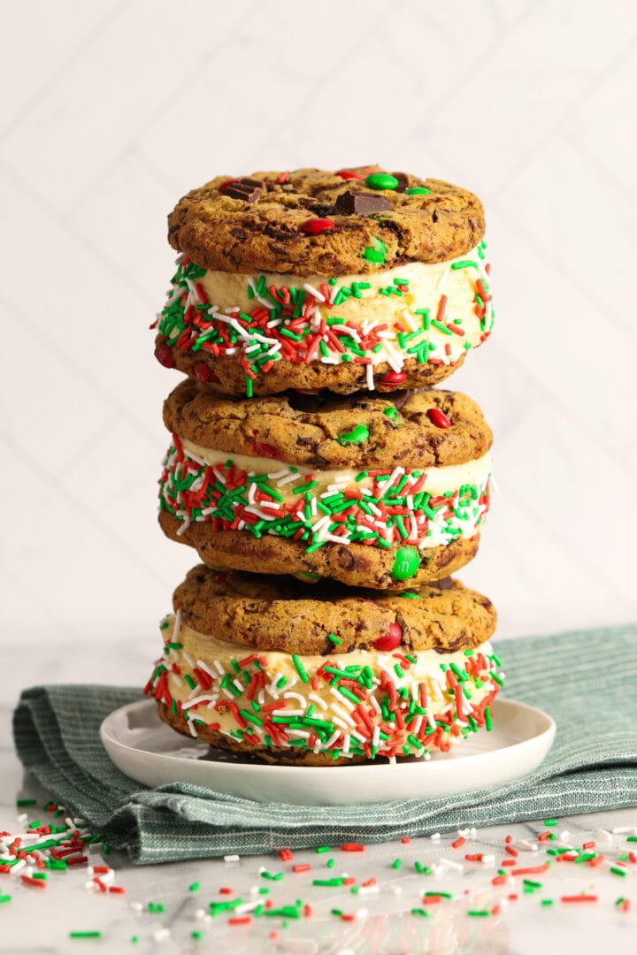 tall stack of three christmas cookie ice cream sandwiches with red and green sprinkles