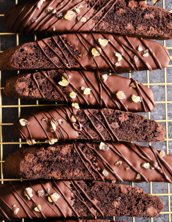 top shot of a gold cooling rack filled with chocolate biscotti.