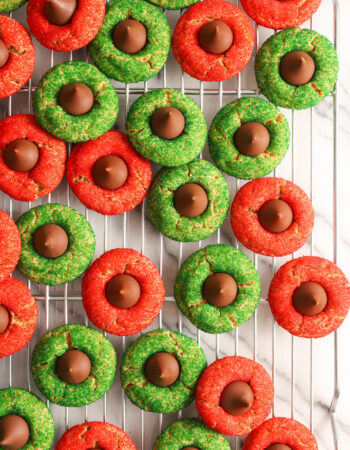 red and green peanut blossom cookies on a silver cooling rack.