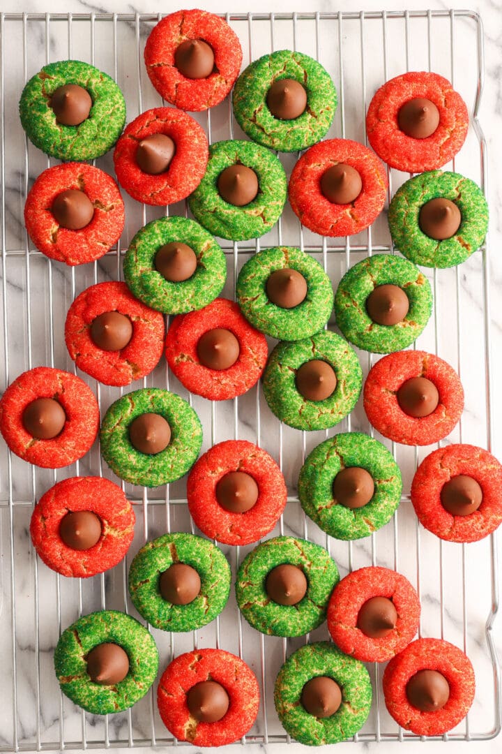 red and green peanut blossom cookies on a silver cooling rack.
