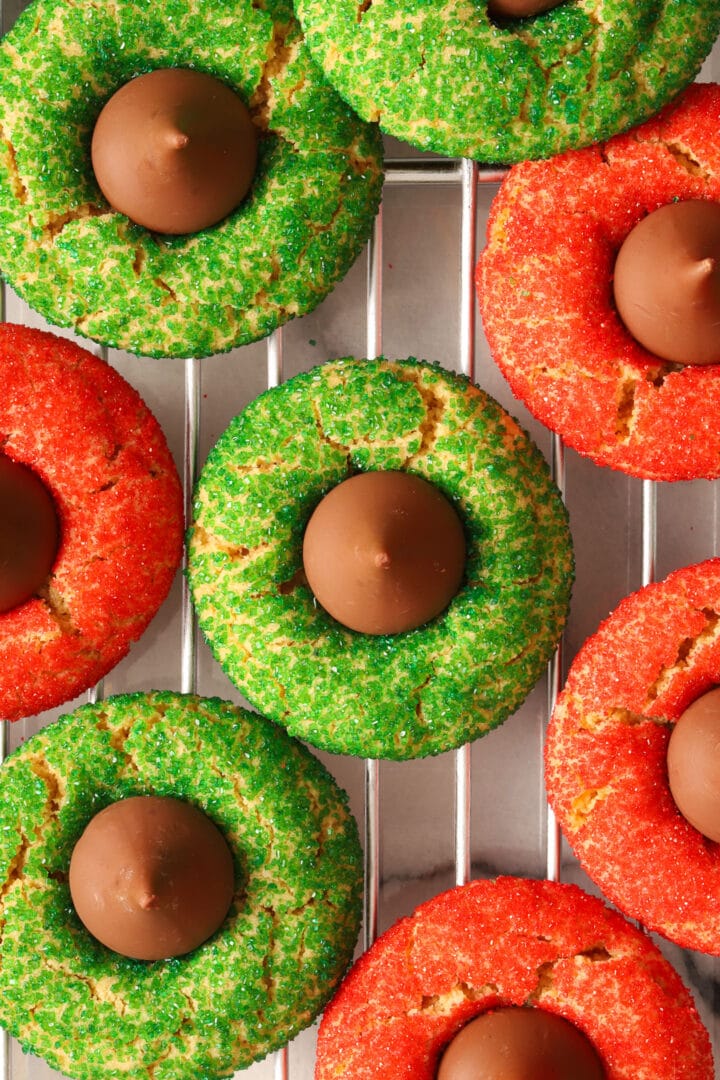 red and green peanut blossom cookies on a silver cooling rack.
