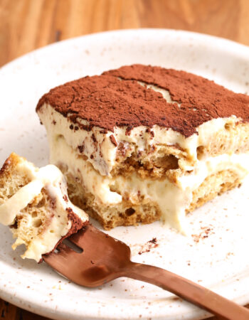 slice of tiramisu with a bite taken out, resting on a rose gold fork