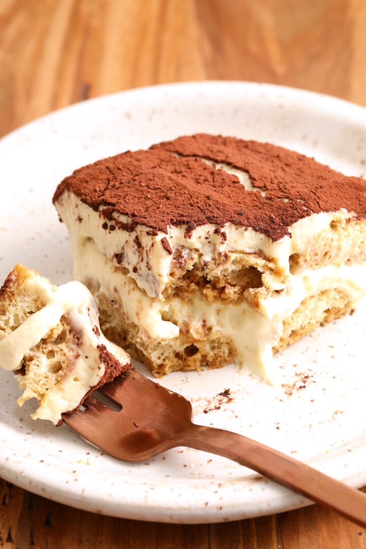 slice of tiramisu with a bite taken out, resting on a rose gold fork
