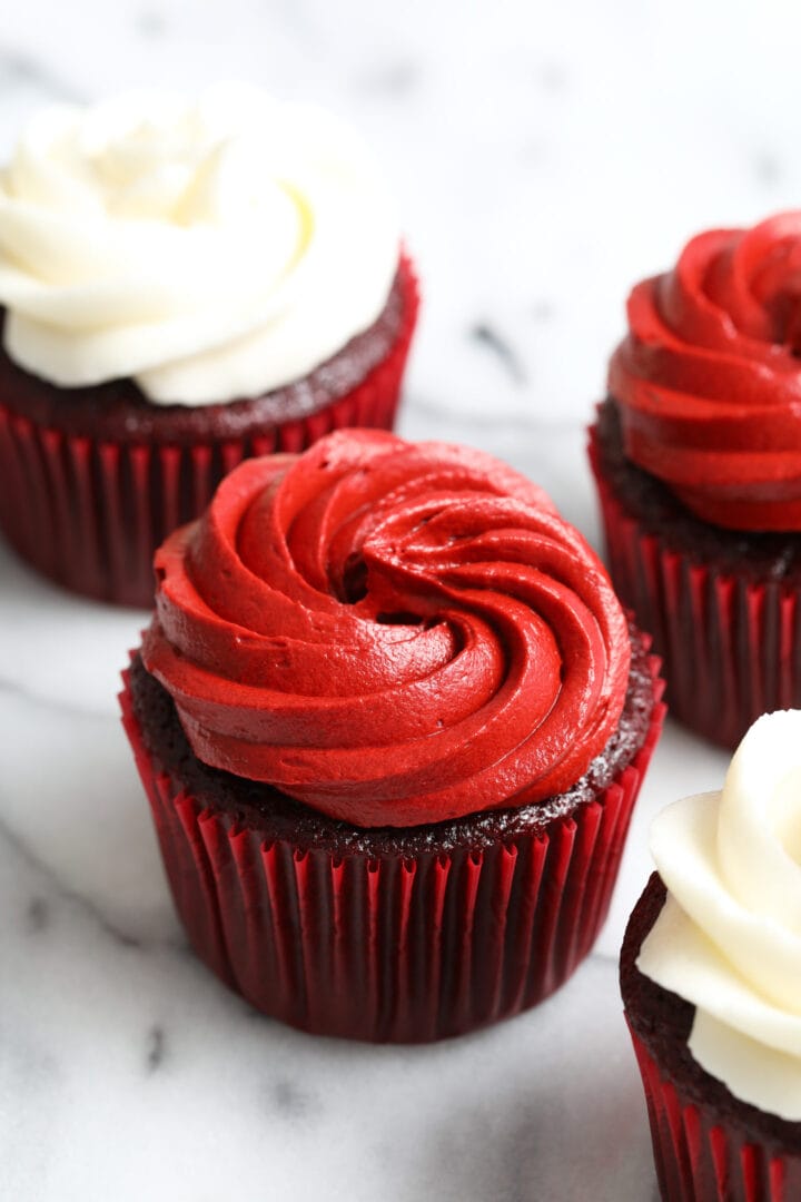 red velvet cupcake in a red wrapper, frosted with red velvet buttercream