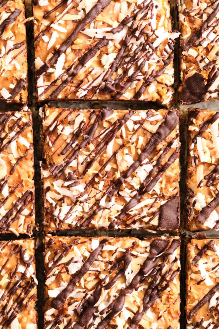 top view of coconut caramel cookie bars that are topped with toasted coconut and drizzled in chocolate.