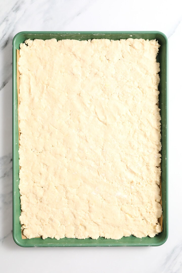 green sheet pan of biscuit dough, ready to be baked.