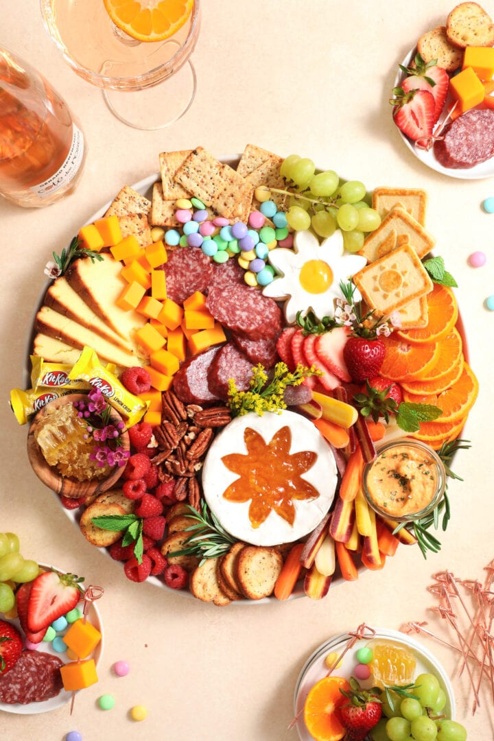 colorful charcuterie board with fresh fruit, vegetables, cookies, nuts, and cheese.