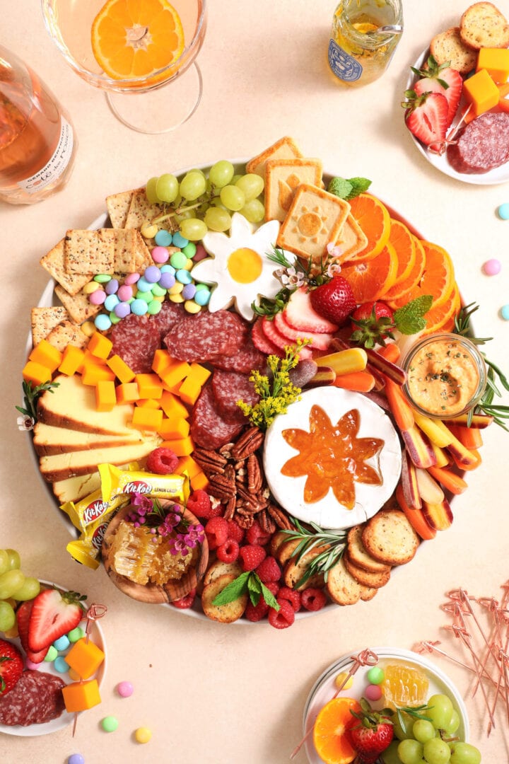 colorful charcuterie board with fresh fruit, vegetables, cookies, nuts, and cheese.