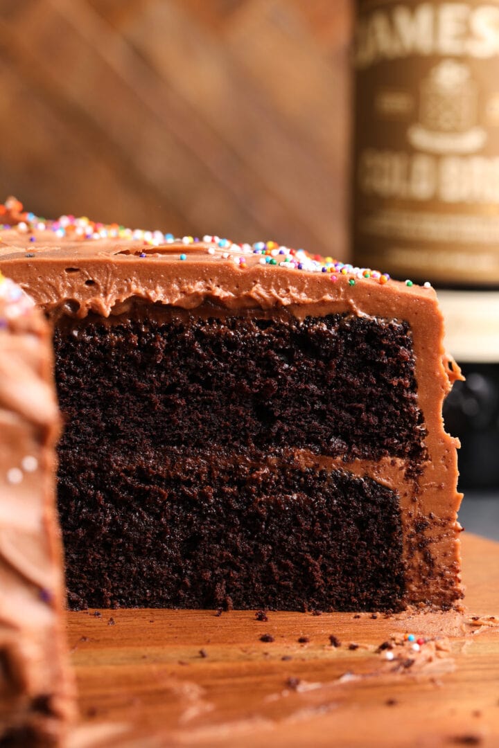 cut side of a devil's food cake with chocolate frosting and rainbow sprinkles.